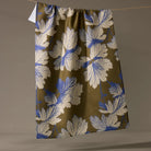 Floral patterned fabric hanging on a line against a plain background