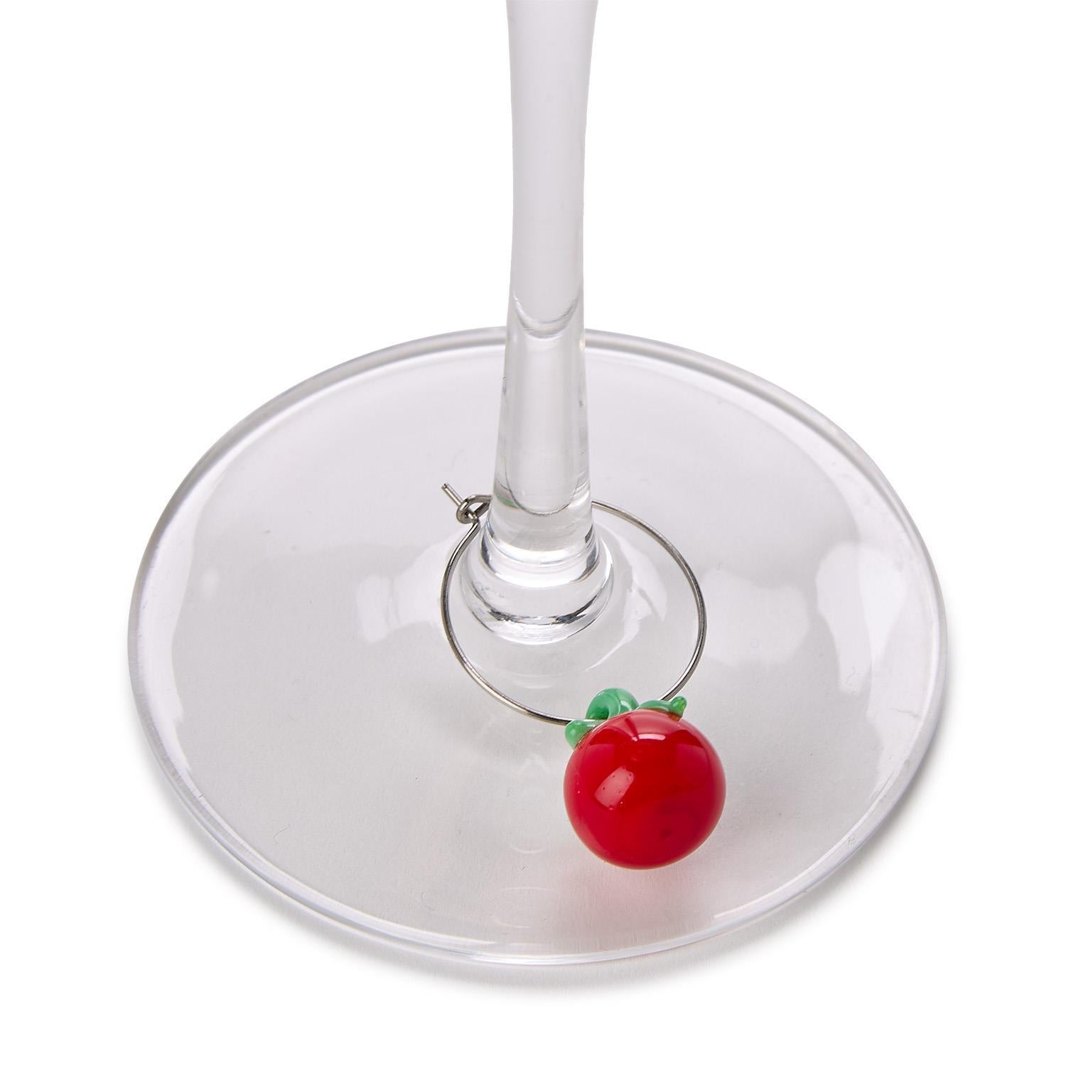 Wine glass charm shaped like a red apple on a white background